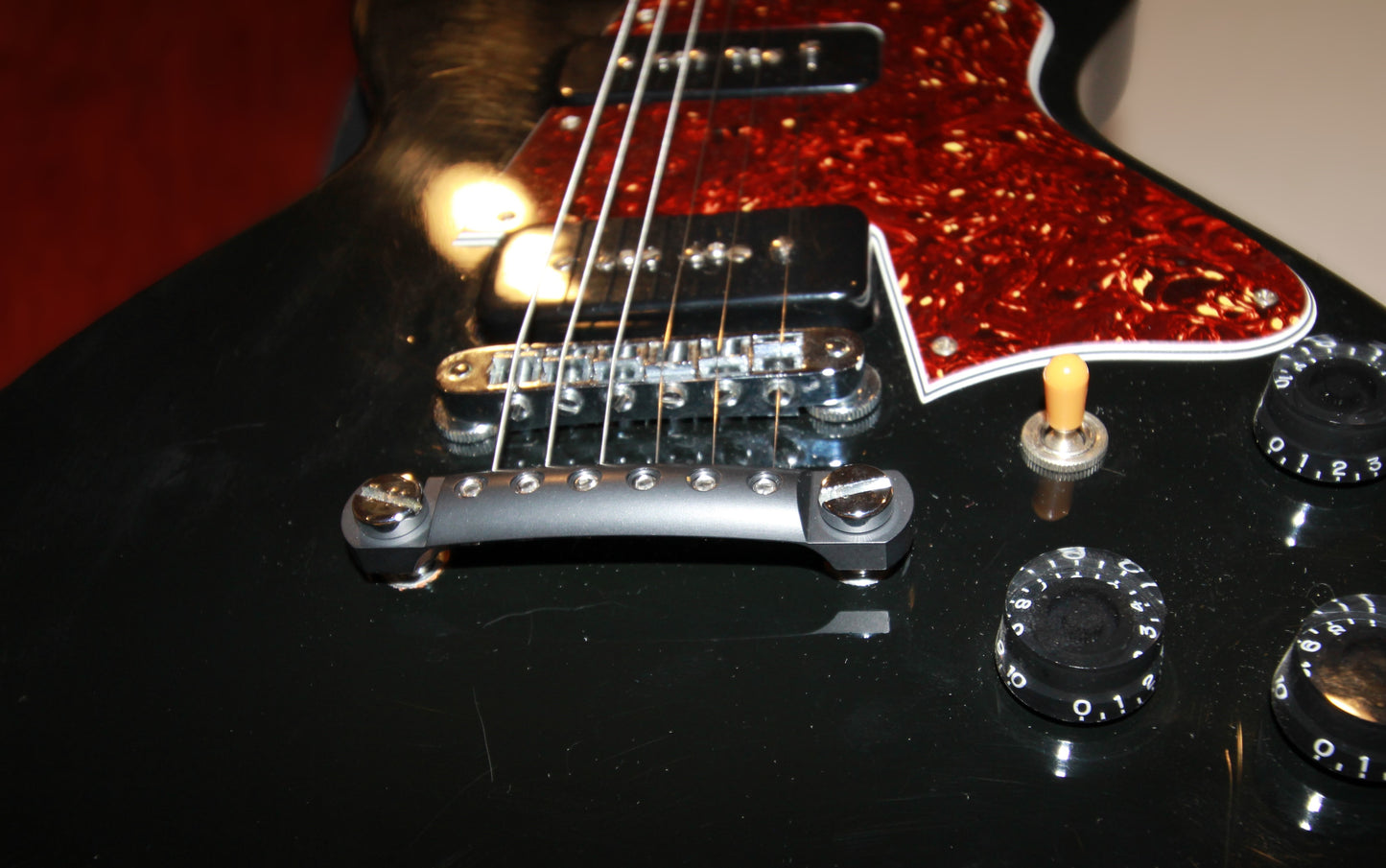 A black CNC Aluminum Stopbar on a Gibson Les Paul guitar