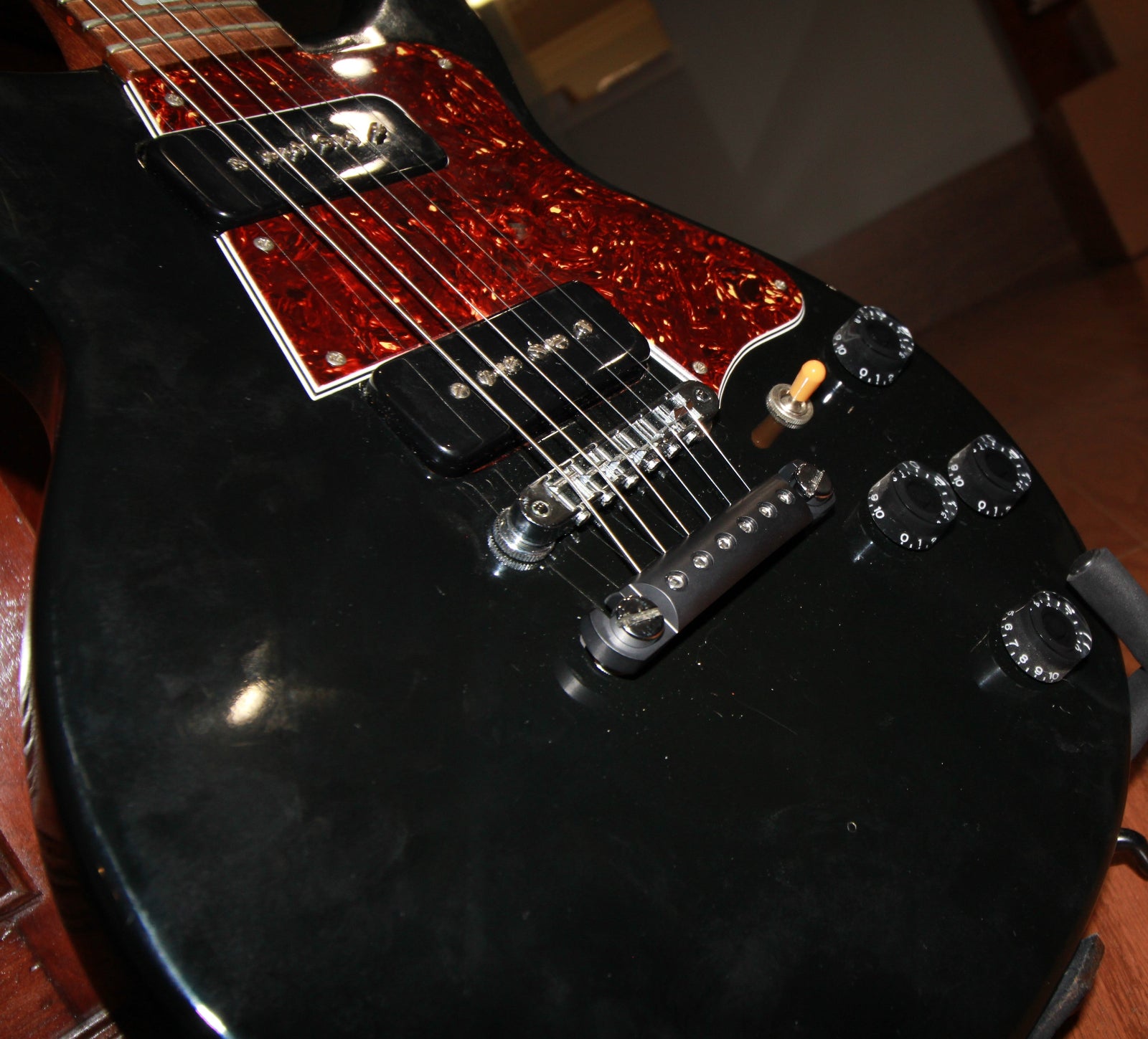 A black anodized Steadfast Stopbar on a black Gibson Les Paul guitar